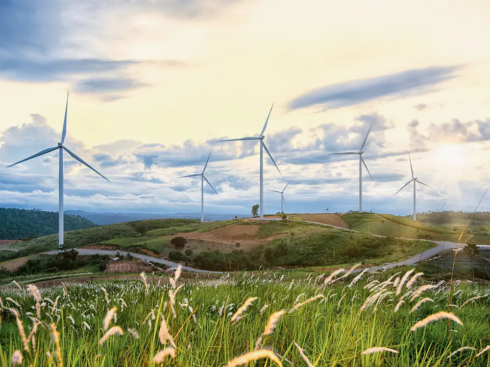 Turbine eoliche su colline con erba incolta