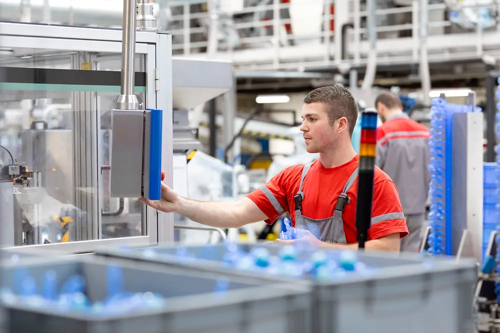 An employee is using a machine in production