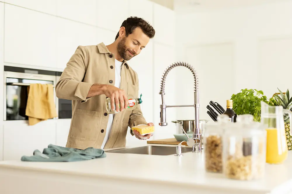 Uomo che lava i piatti in cucina