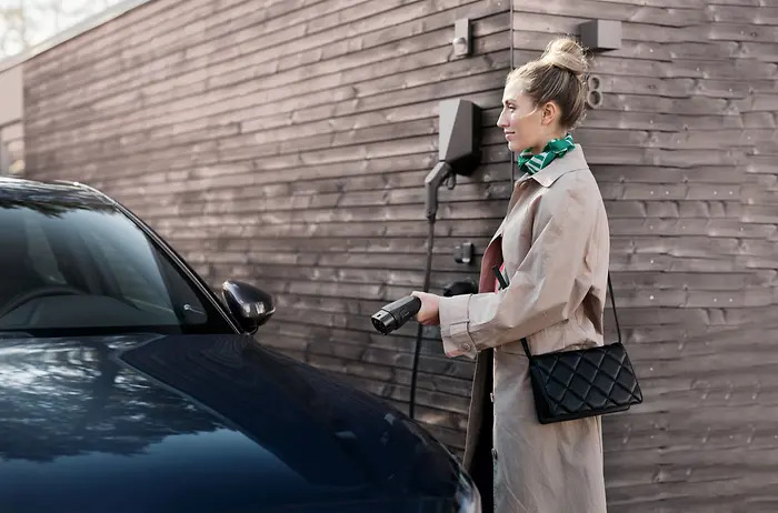 Donna che ricarica la sua auto elettrica