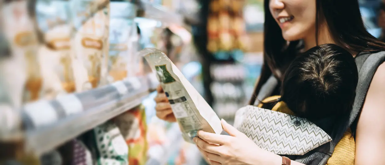 Donna al supermercato che legge le etichette dei prodotti