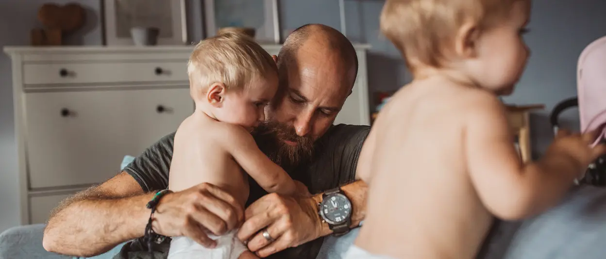 Papà sul divano con gemelli